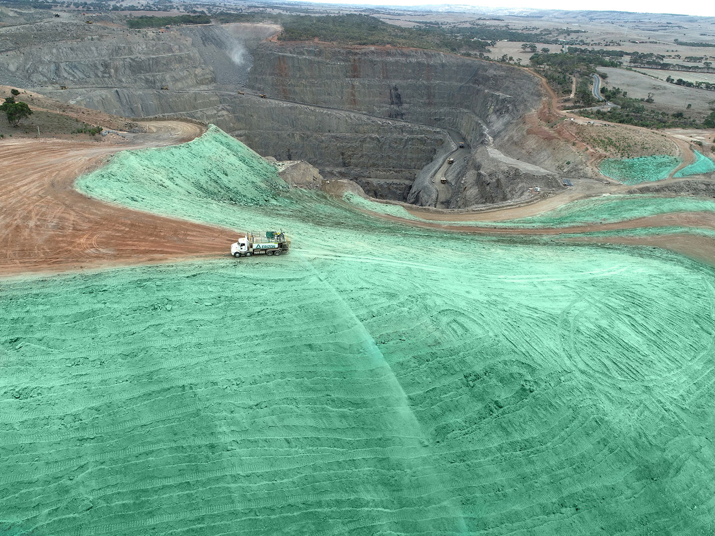 spraying hydromulch down a hill on a mine